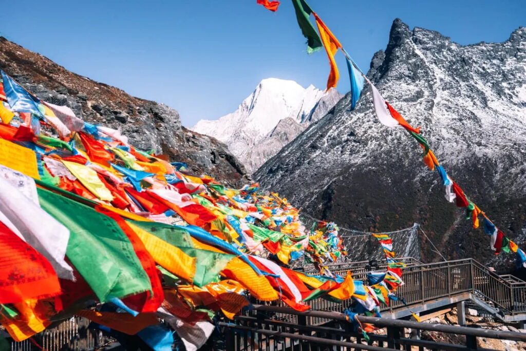 折多山山口彩色經幡隨風飄揚,雪峰背景,四川康定川西藏區