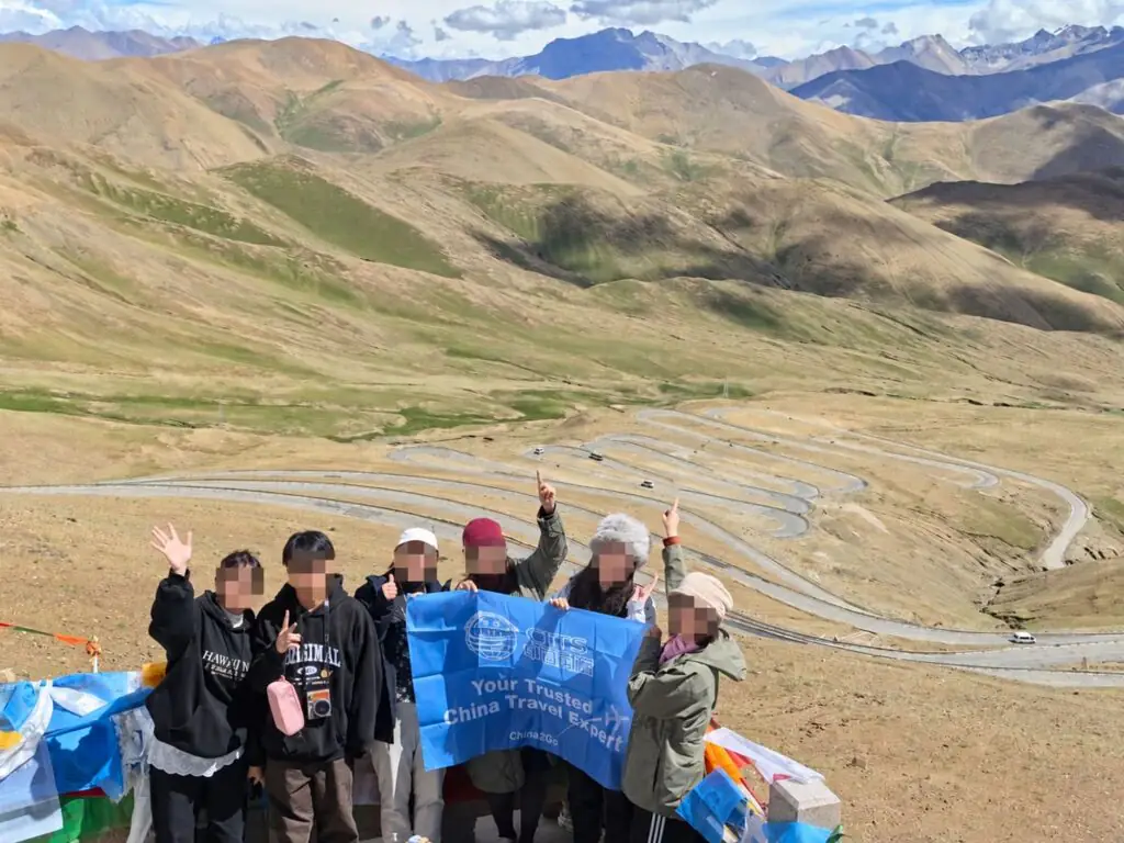 China2Go 評價如何?國旅環球西藏團客人怎麼說 - CITS China International Travel Service 國旅環球西藏團客人在加烏拉山口觀景台合影,背景為前往珠峰的盤山公路