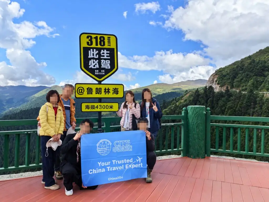 China2Go 評價如何?國旅環球西藏團客人怎麼說 - CITS China International Travel Service 國旅環球西藏團客人在林芝魯朗林海觀景台的 318 國道地標前合影